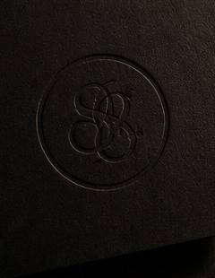 Blind-embossed Solace brand seal on black card